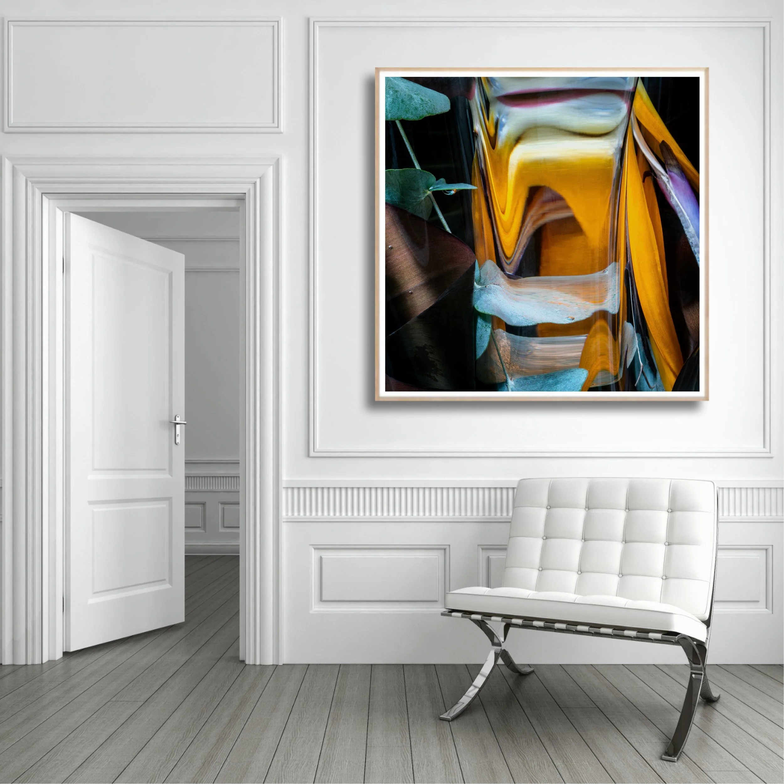 A modern white room with decorative wall moldings, a door slightly ajar, a large abstract painting with vibrant yellow, purple, and green colors hanging on the wall, and a white leather chair with a metal frame positioned to the right of the painting