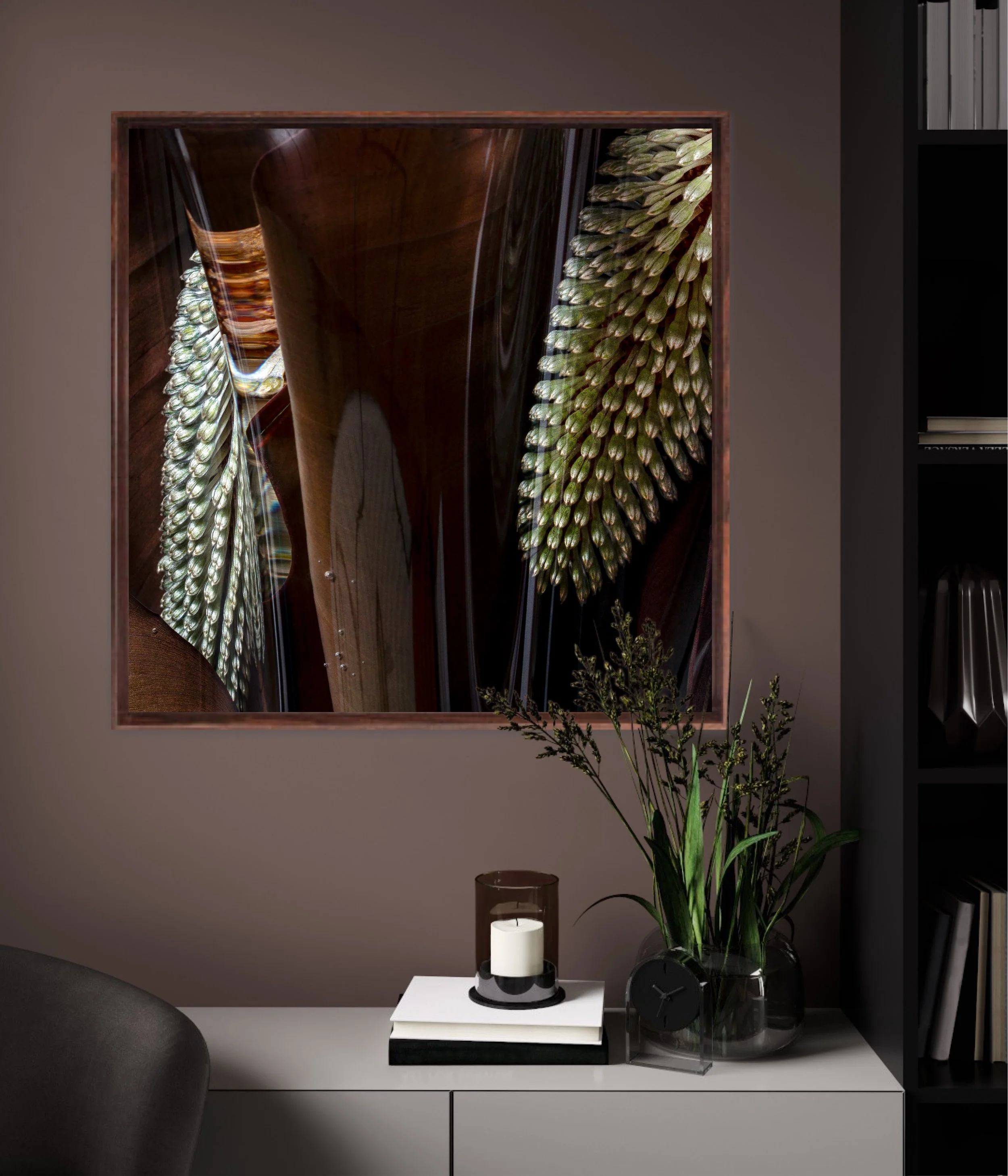 Interior decor with a black clock, white candles, a glass vase with green leaves, and framed wall art featuring abstract designs in browns and greens, in a modern room.