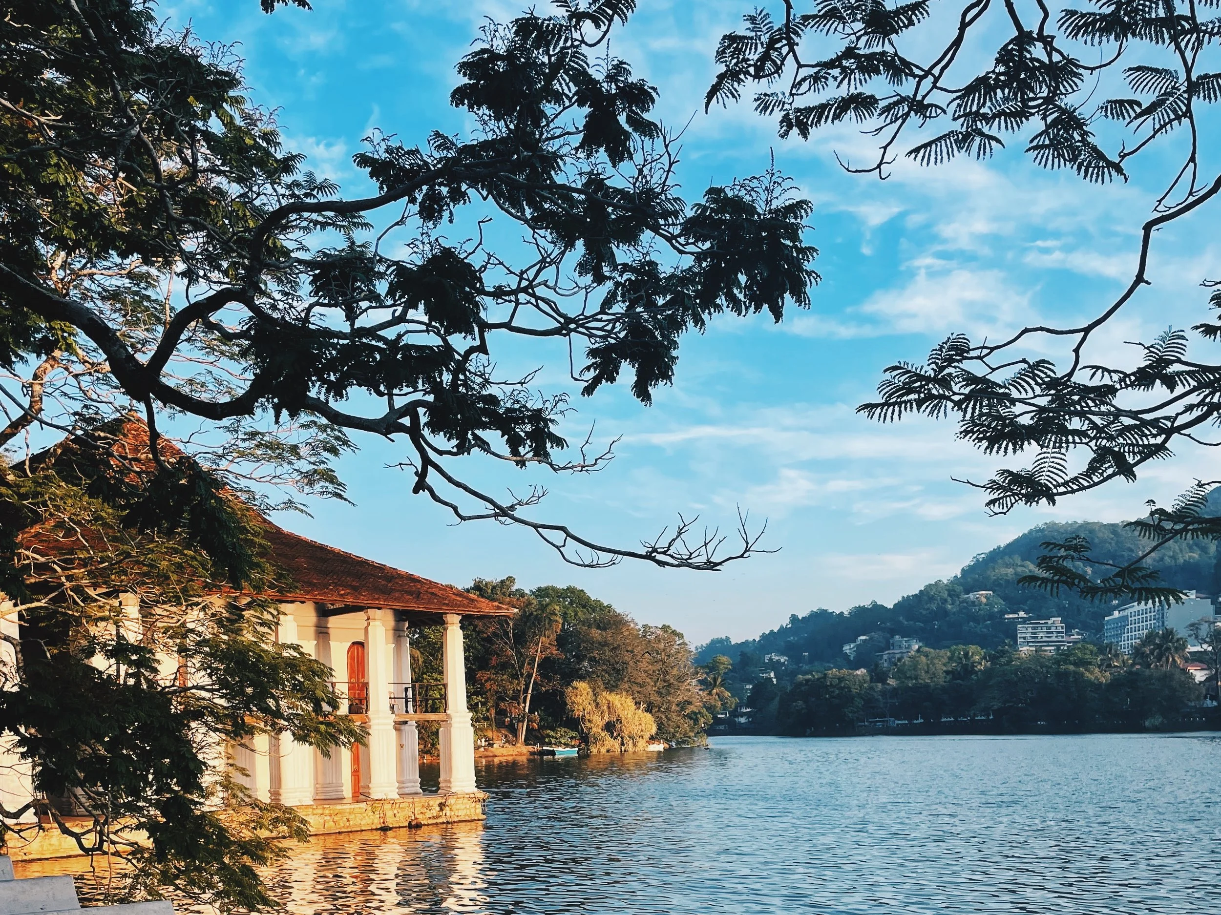 colonial structure next to lake and surrounded by trees and mountains