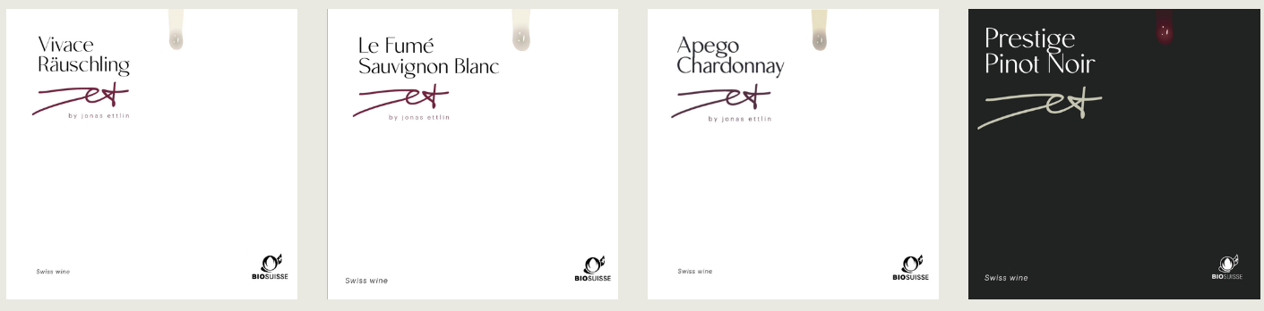 JET Autogramm Weinflaschenetiketten nebeneinander, von links nach rechts: Vivace Räuschling, Le Fumé Sauvignon Blanc, Aprego Chardonnay, Prestige Pinot Noir.