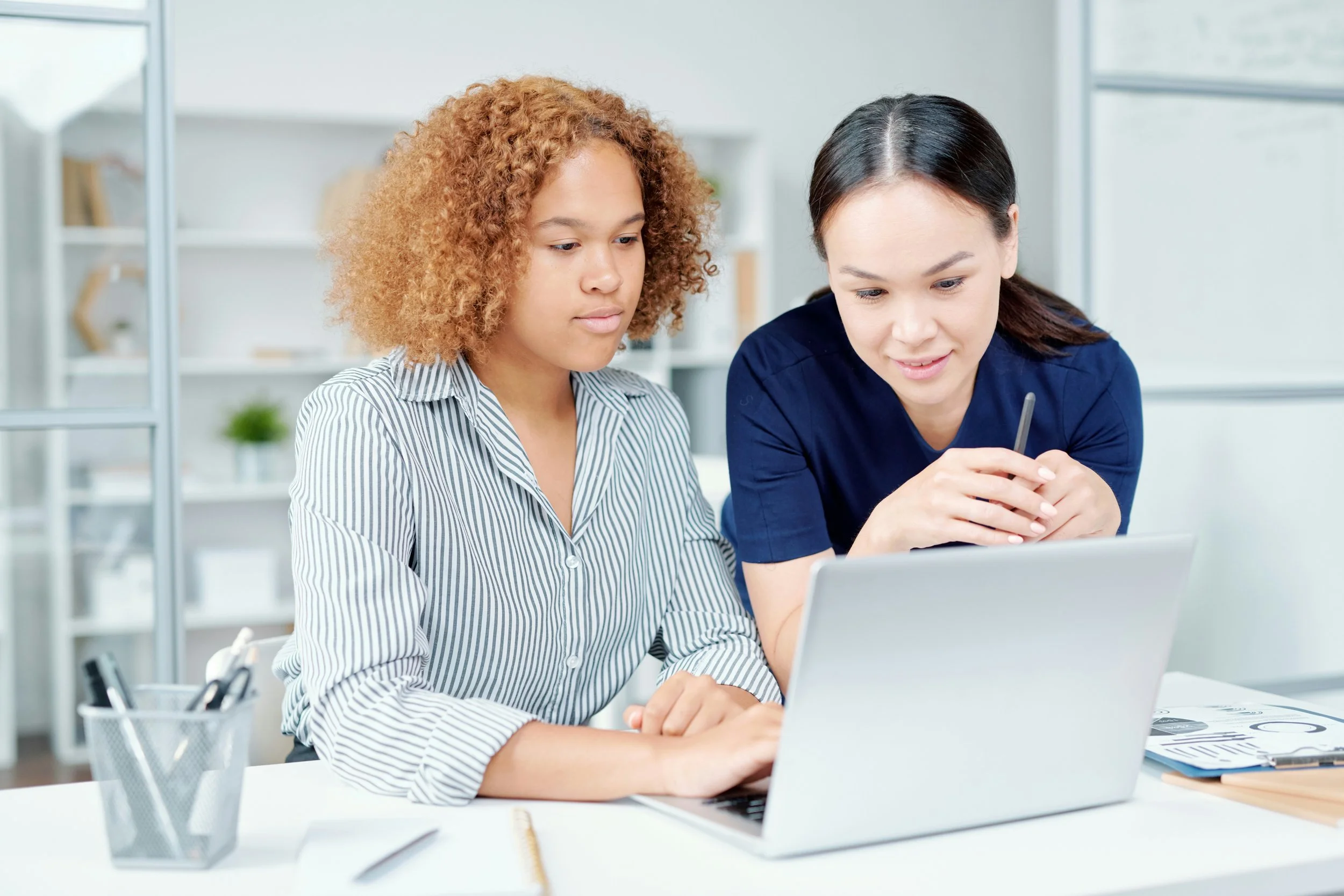 Unsplash - two-women-sitting-at-a-desk-working-with-each-other