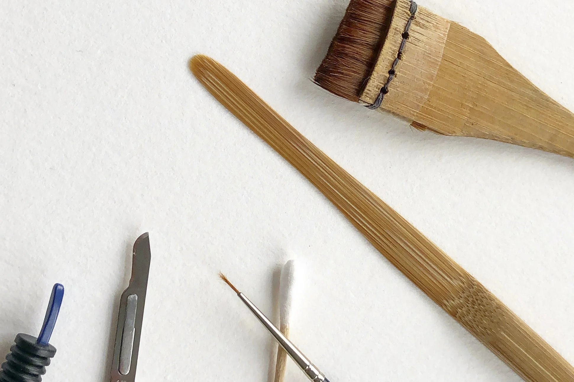 Scalpel, brushes and bamboo spatula on the bench
