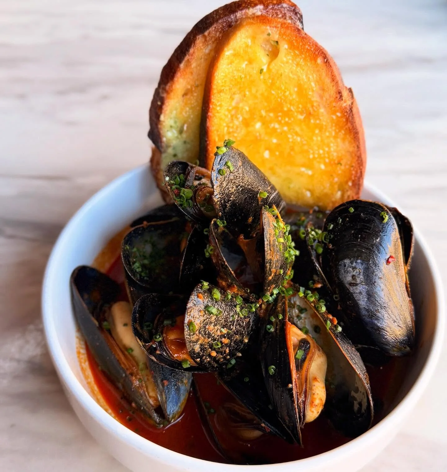 Another new addition to the menu that the whole table will love: mussels with peppers, n'duja, orange, thyme, and fresh sourdough.