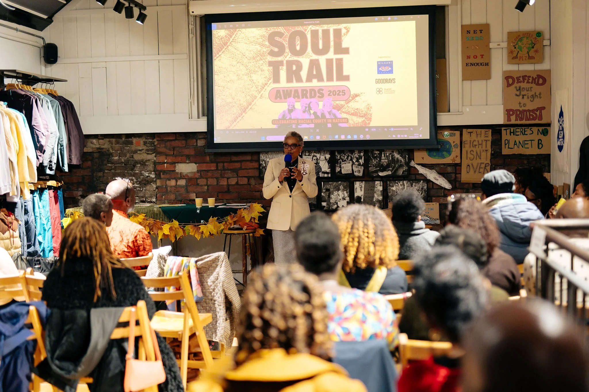  Presenter at front of an audience with Soul Trail Awards 2025 on a large screen behind them  