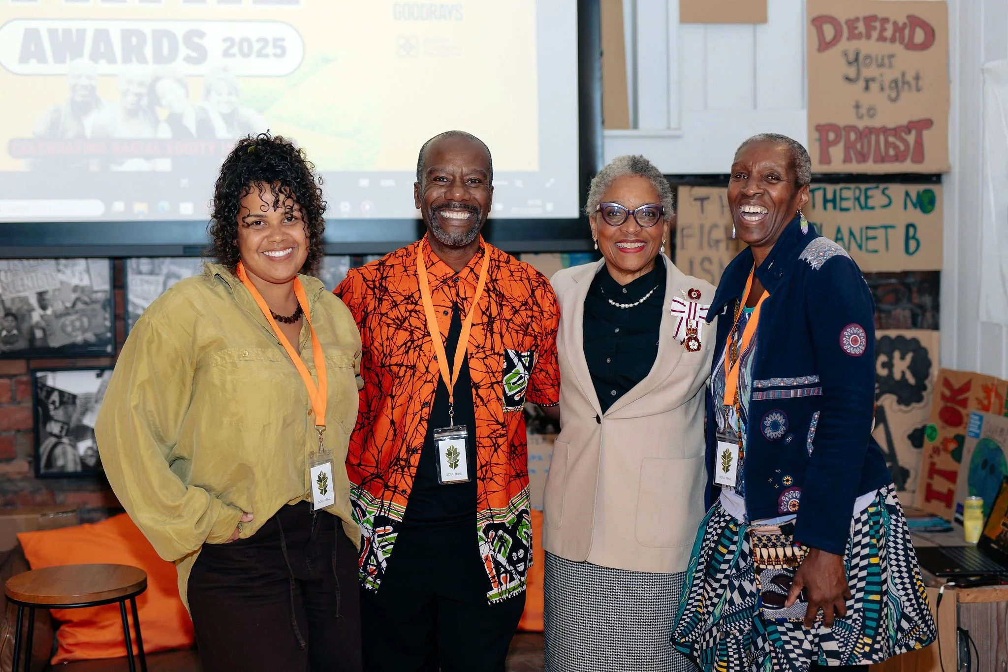  Group photo of 4 people wearing Soul Trail logos on lanyards  
