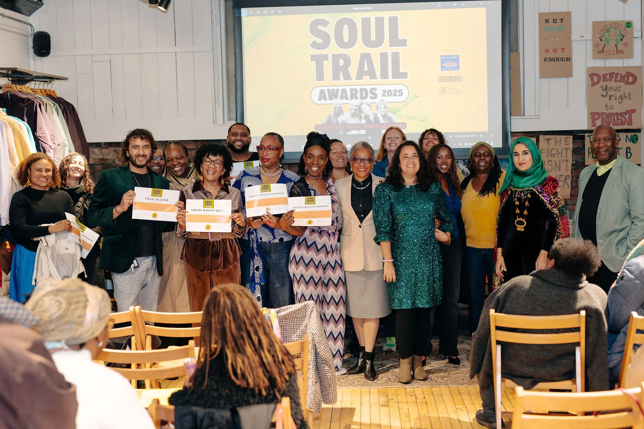  Group photo of awardees holding certificates and attendees 