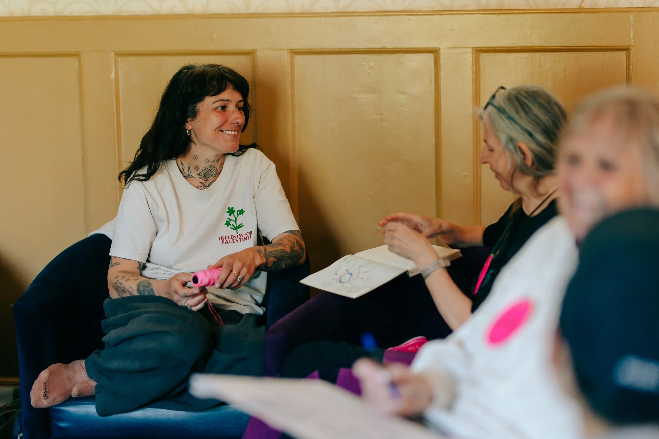 Participants sit in armchairs chatting with each other