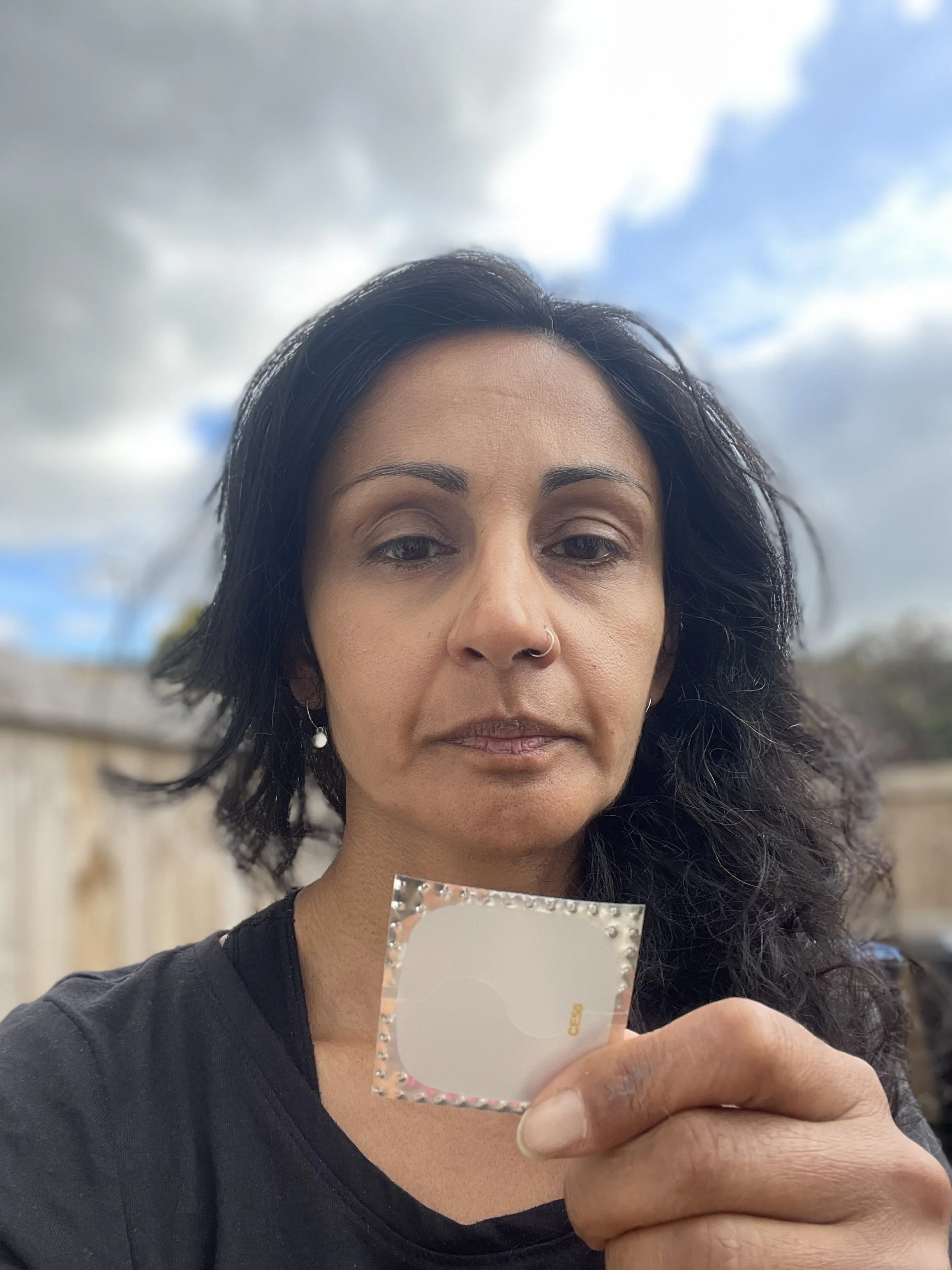 Aneela holds up a HRT patch