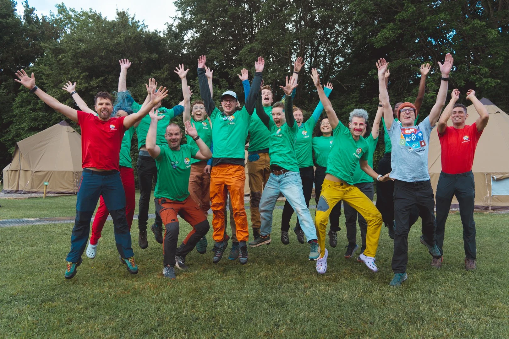 A group photo where ClimbOut instructors in green t-shirts jump into the air.