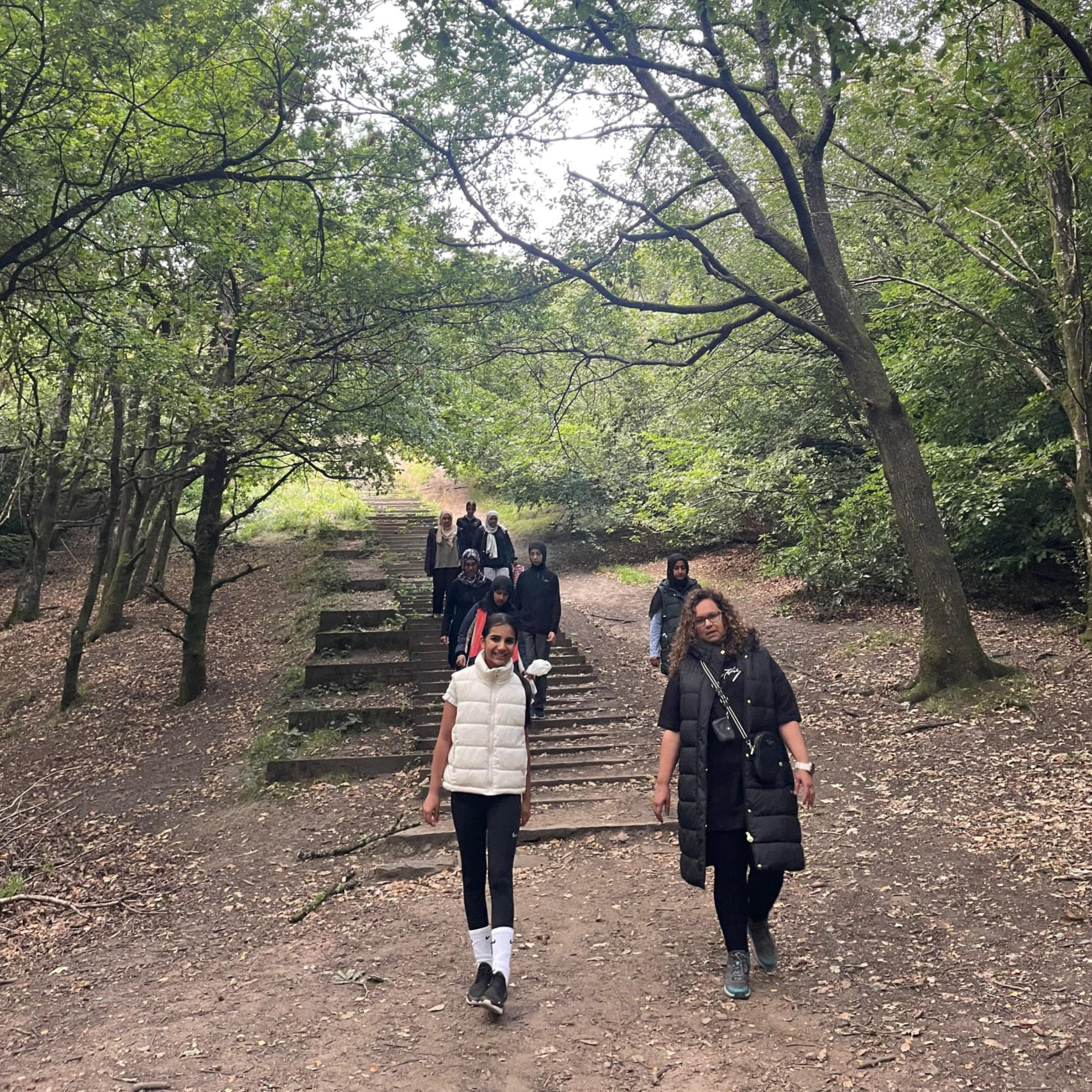 Group of people smiling walking through a forest