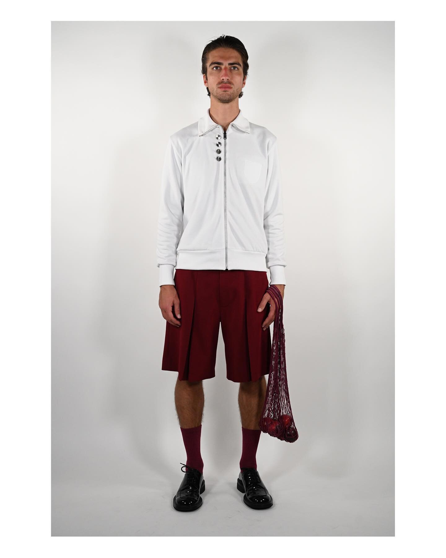 Look 1: Our Reversable Track Jacket and Inverted Pleated Burgundy Shorts. 

This design draws inspiration from the complex nature of identity and loyalty in sports, particularly football, and incorporates elements from both German and Turkish uniform