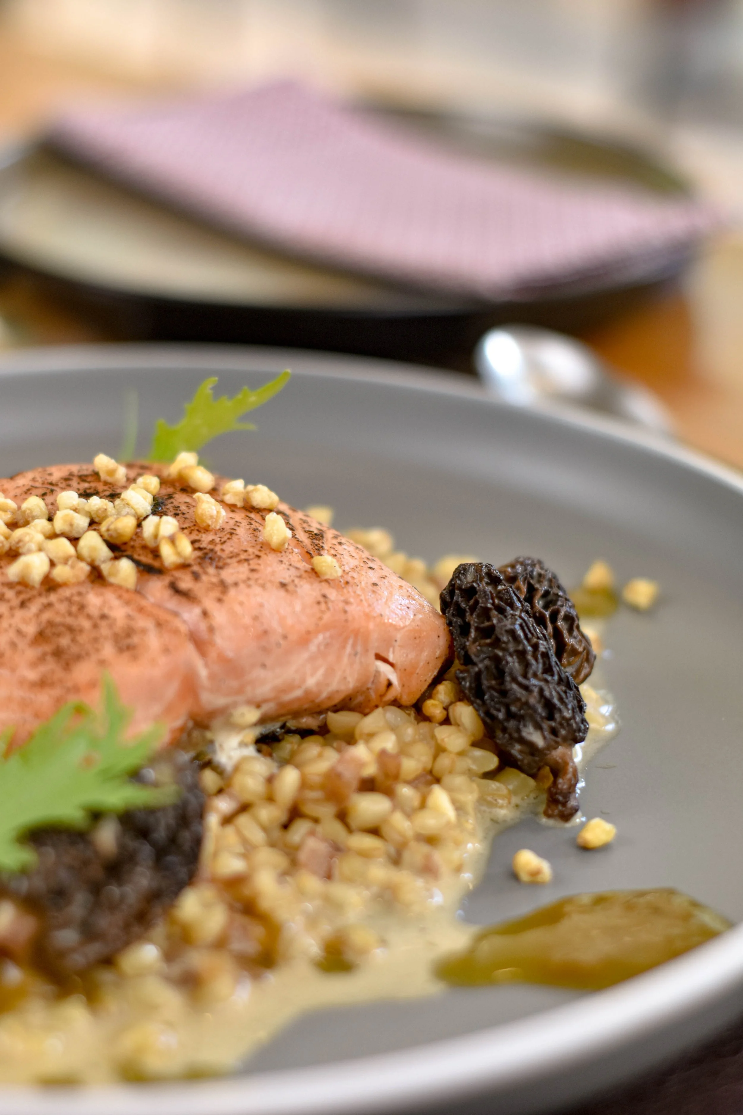 Plato con salmón, nueces, setas y salsa en un plato gris