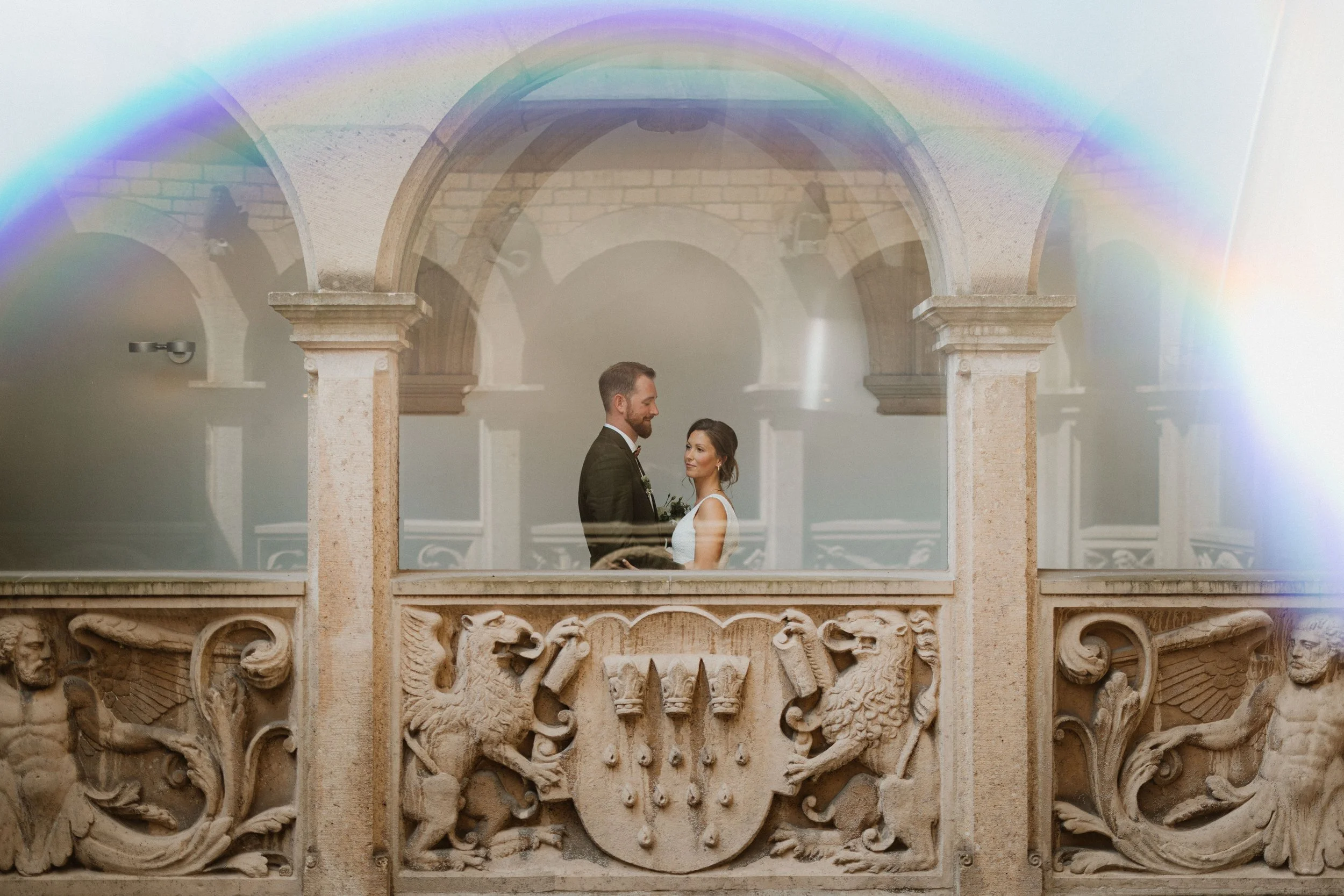 Brautpaar steht zusammen im Kölner Rathaus vor dem Kölner Wappen