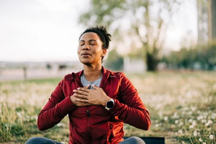 A woman breathing with hands on her chest