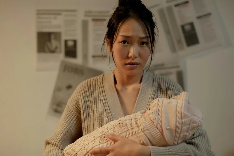 A mom holding her baby child with a look of concern