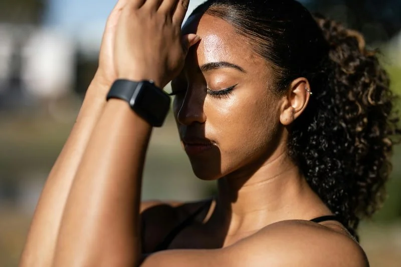 A woman with hands up to her face breathing