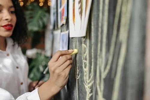 Woman looking inspired writing on a chalk board and looking hopeful