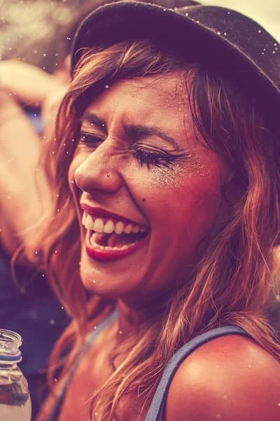 Woman smiling ecstatically with sparkles around her.