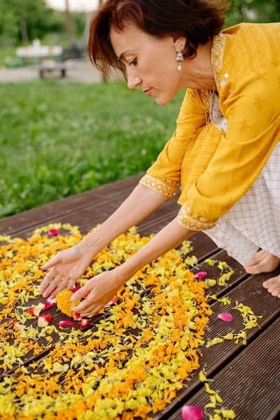 Woman creating art honoring 3rd chakra manipura, looking thoughtful and reverant