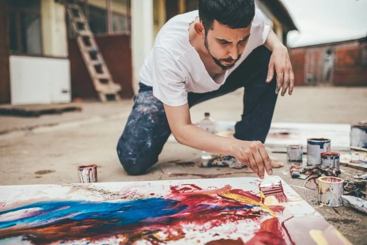 a man painting on the floor