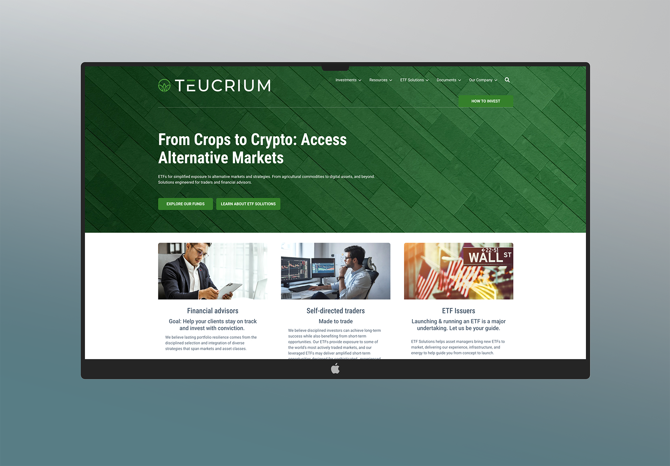 On a computer monitor, a website homepage for TEUCRIUM features a green background with white text, navigation menu at the top, and sections about investing in alternative markets, with images of professionals working and stock market graphics.