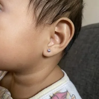 Close-up of a child's ear with a small earring