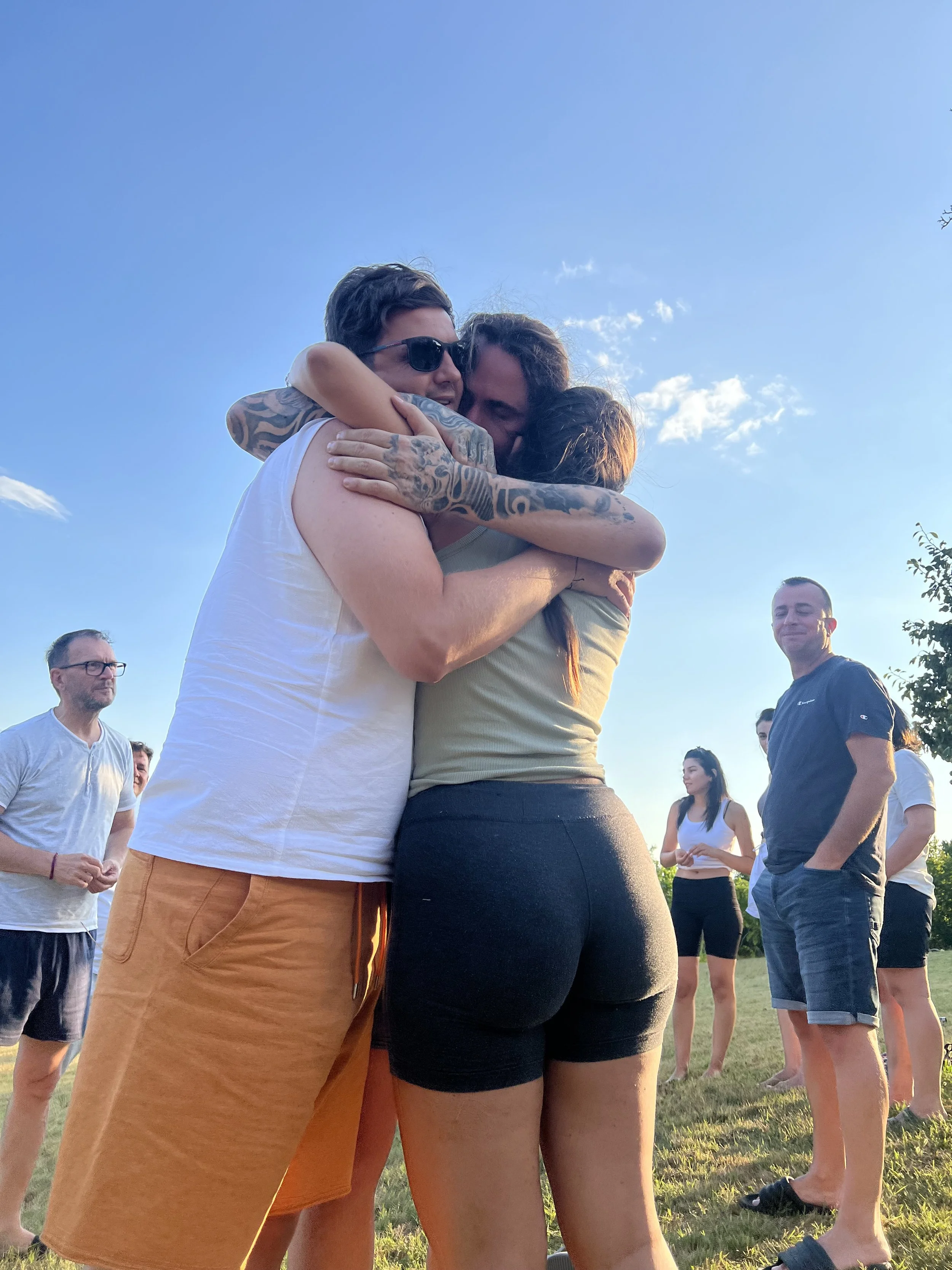 Two people hugging in our healing retreats in Europe at sunset outdoors, in community