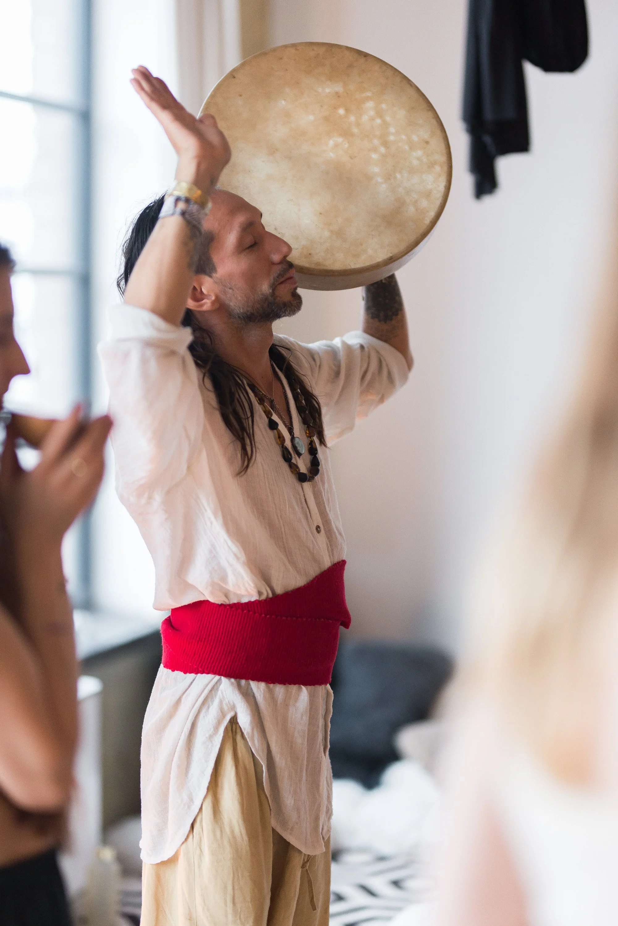 Toltec Medicine plays a large drum during a cacao ceremony 