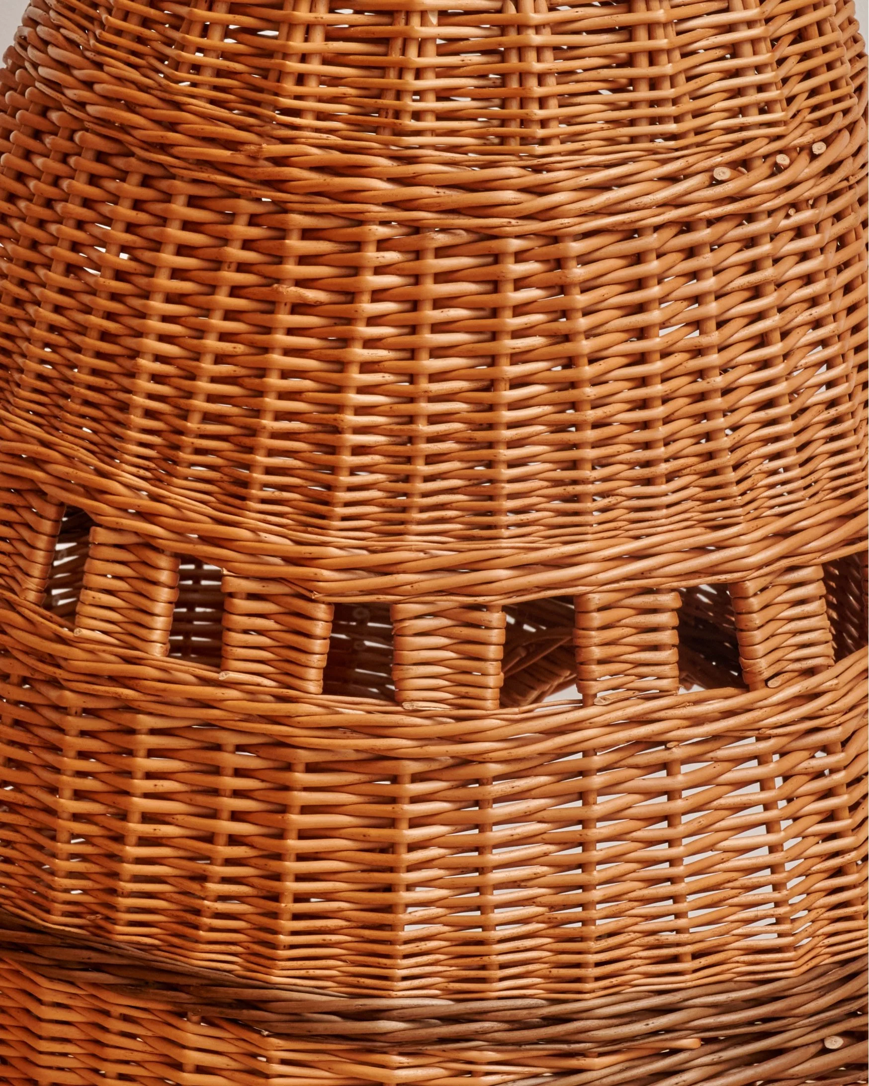 Close-up of woven wicker furniture with intricate pattern and natural brown color.