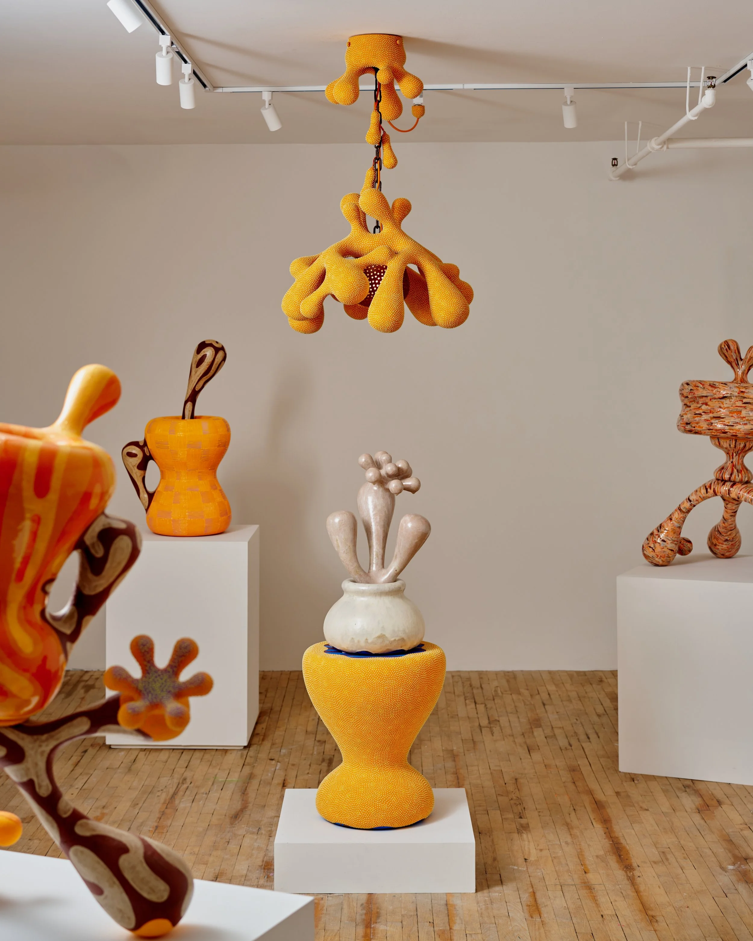 Artistic ceramic sculptures displayed in an art gallery, featuring abstract and organic forms with vibrant colors and intricate textures. Joël Brodovsky-Adams.