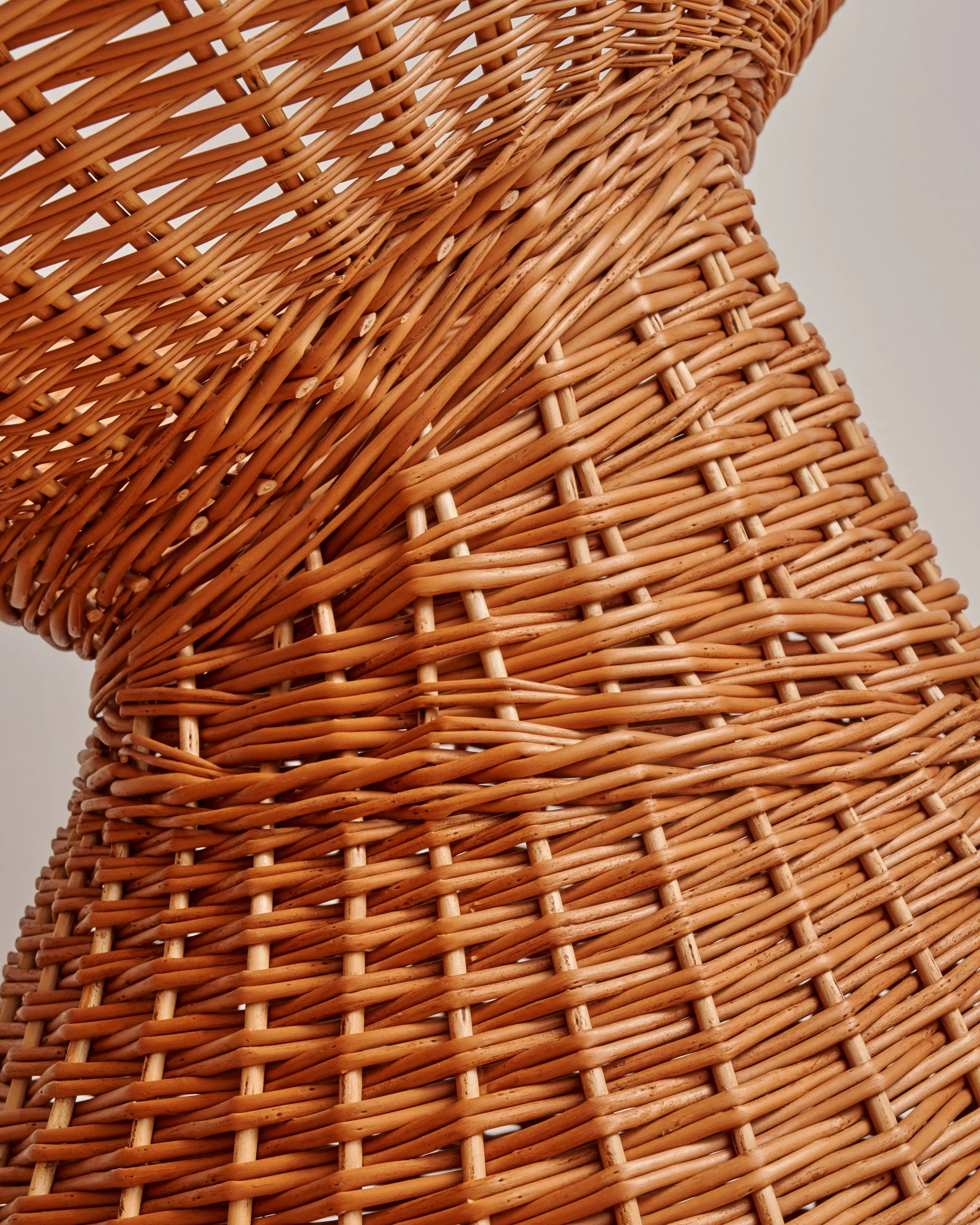 Close-up of a woven wicker chair showing detailed craftsmanship and intricate patterns.
