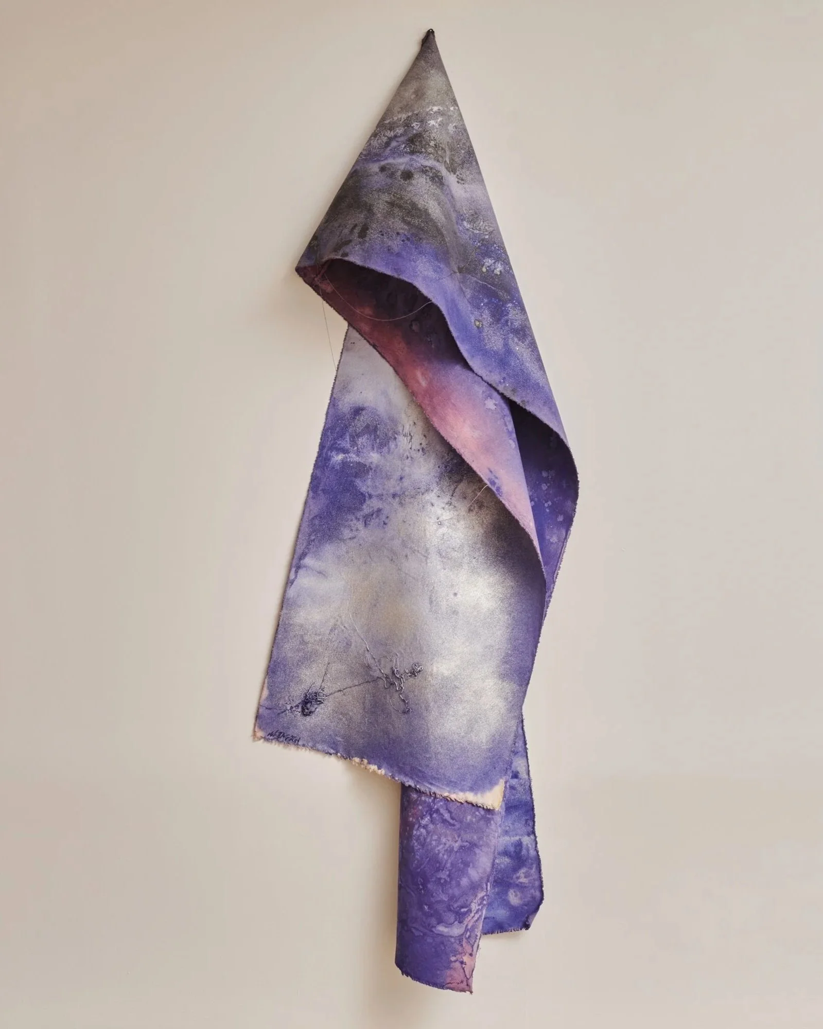 Abstract art piece with dominant red, black, gray, and white colors, featuring splashes and splatters of paint on a long fabric or canvas hanging vertically.
