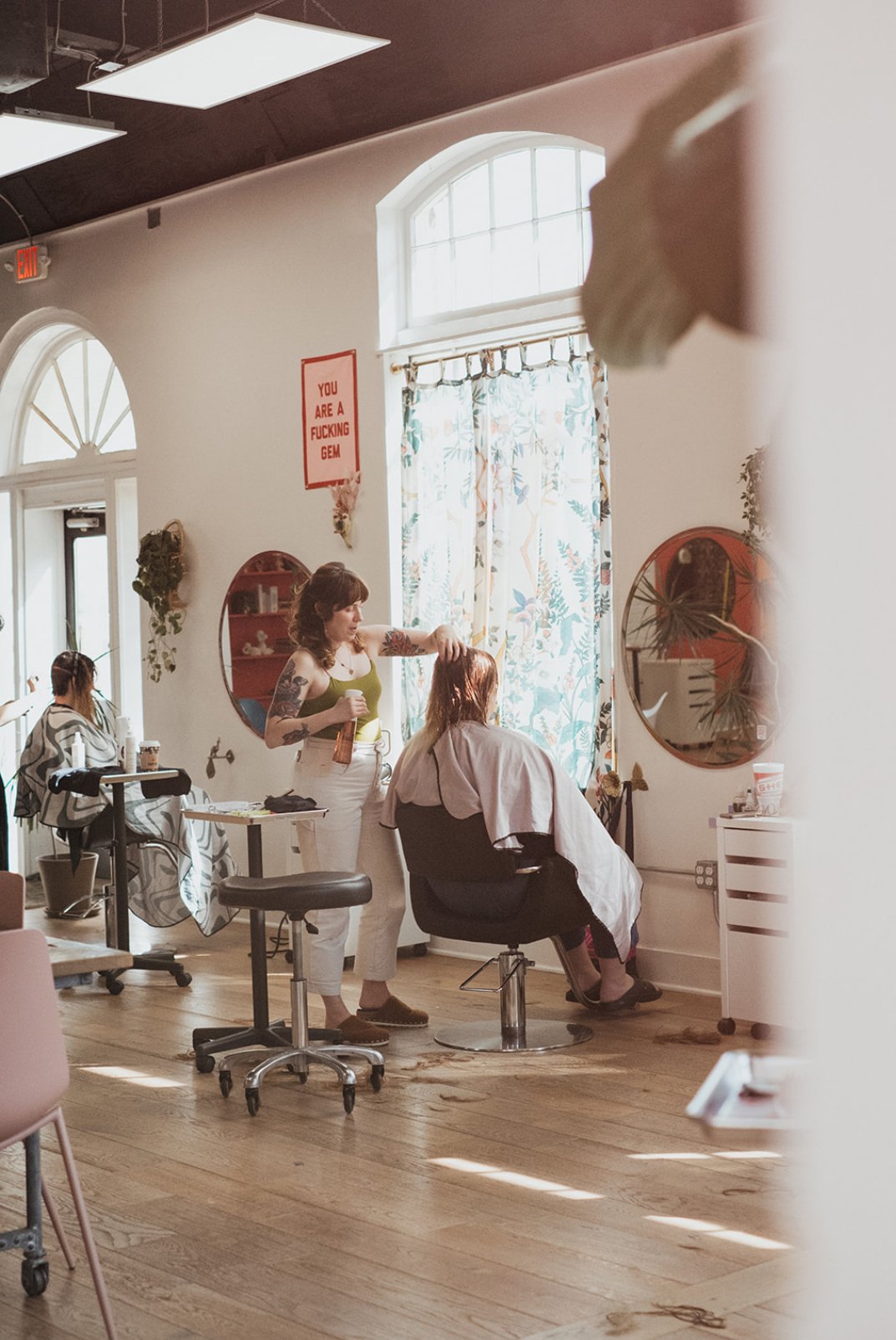 Woman cutting hair at the boutique Ceremony Salon near Chapel Hil NC with natural light.
