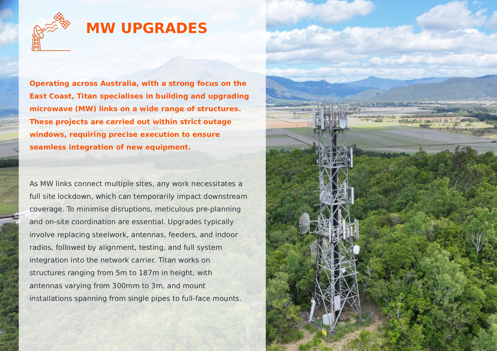 A telecommunications tower with multiple antennas and dishes set in a lush green landscape, with mountains and blue sky in the background.