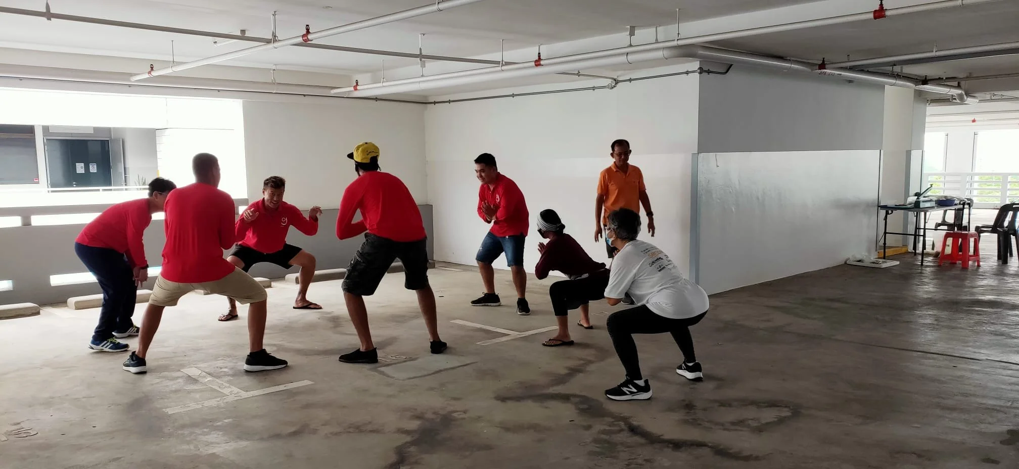 A group of people playing a game or participating in an activity in an indoor parking garage.