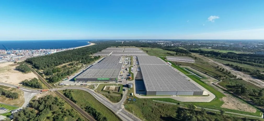 Stort modernt logistik- och lagerkomplex vid europeisk hamn, med flera distributionscenter och omkringliggande infrastruktur.