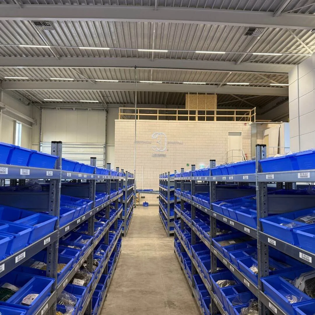 Gång mellan hyllsektioner i Lesjöfors centrallager med blå lagerlådor och tydlig struktur för småvaruplock