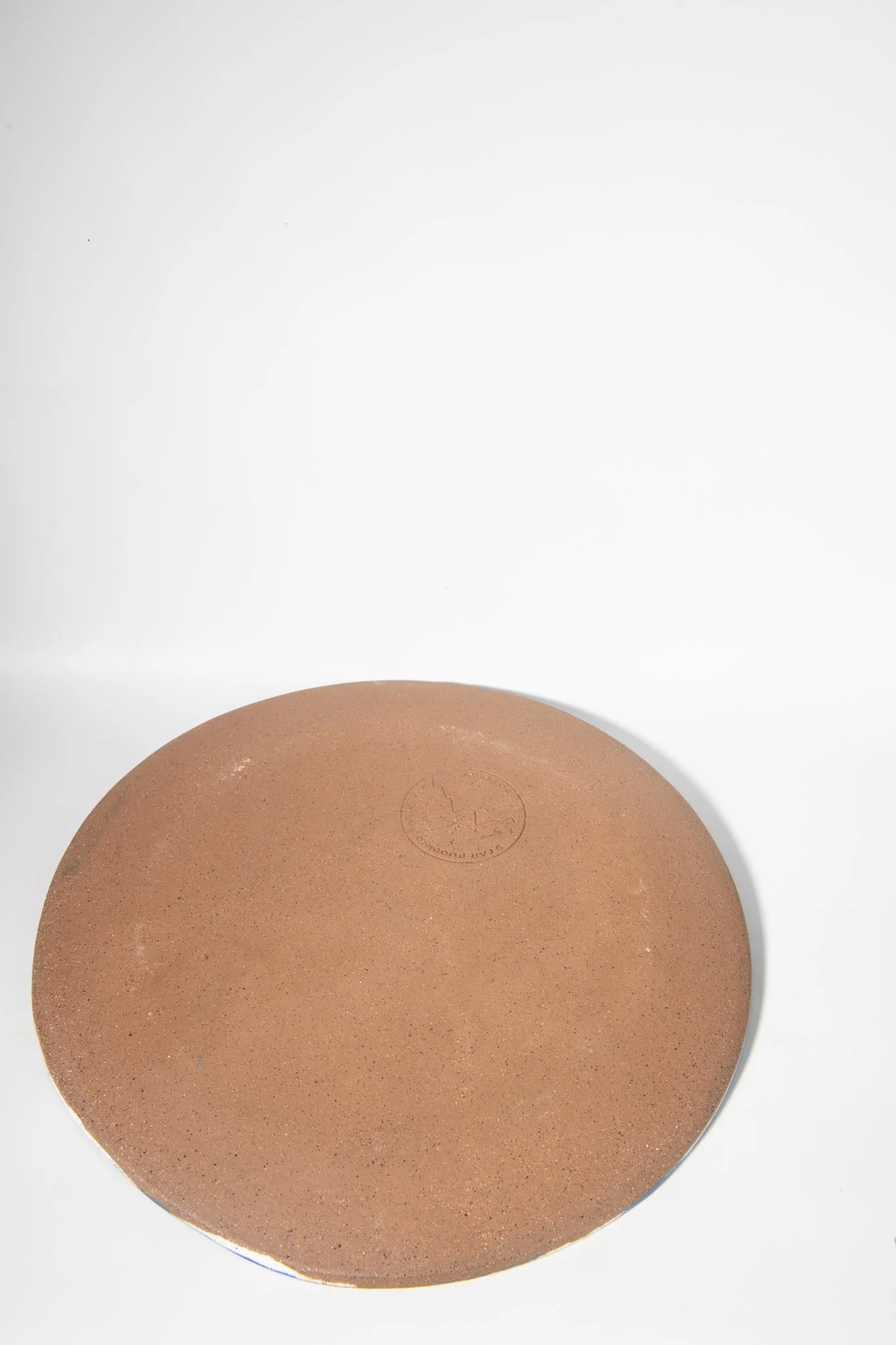 Back view of handmade lemon plate with blue background