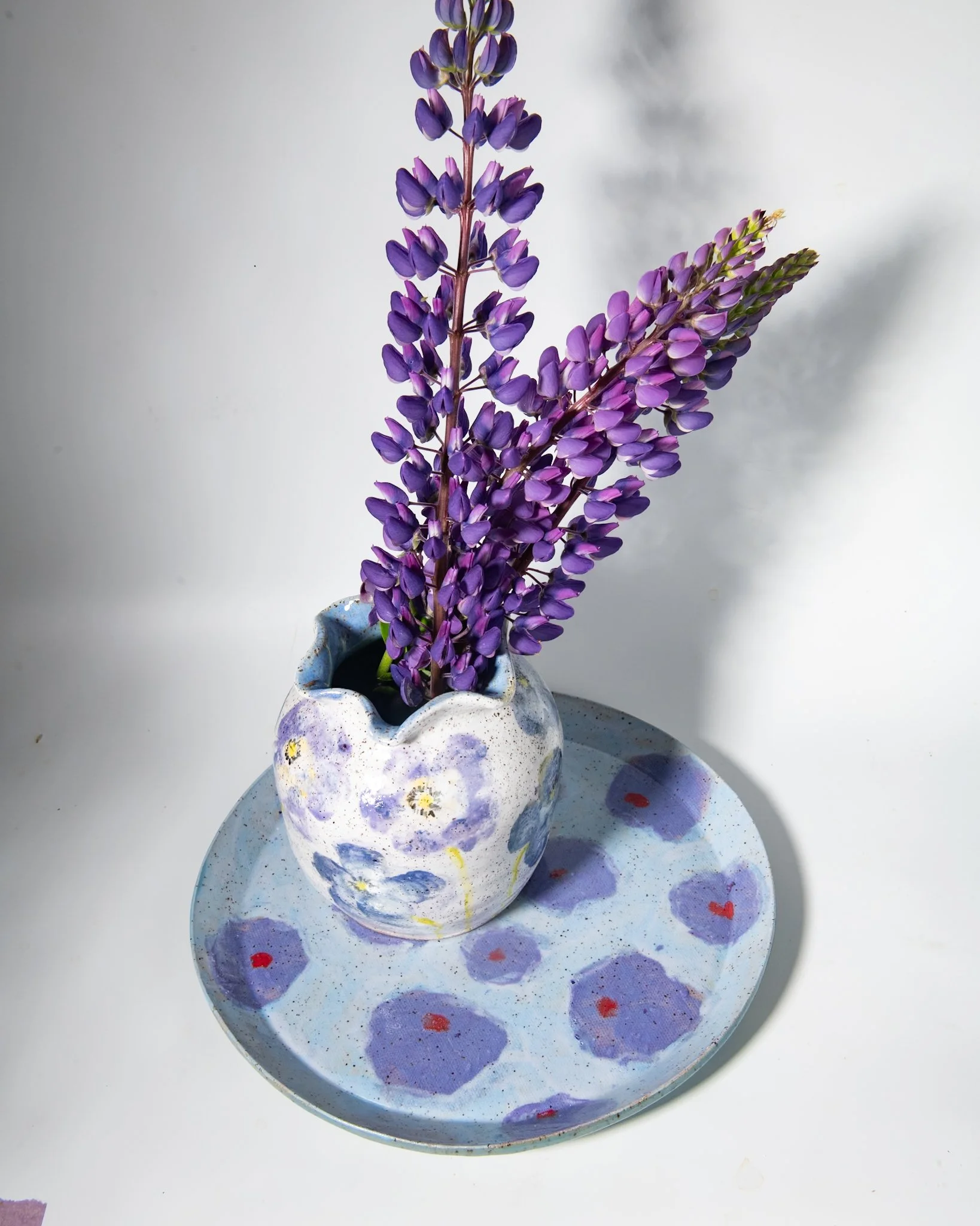 Purple Poppy Ceramic Plate with Poppy Vase resting on it