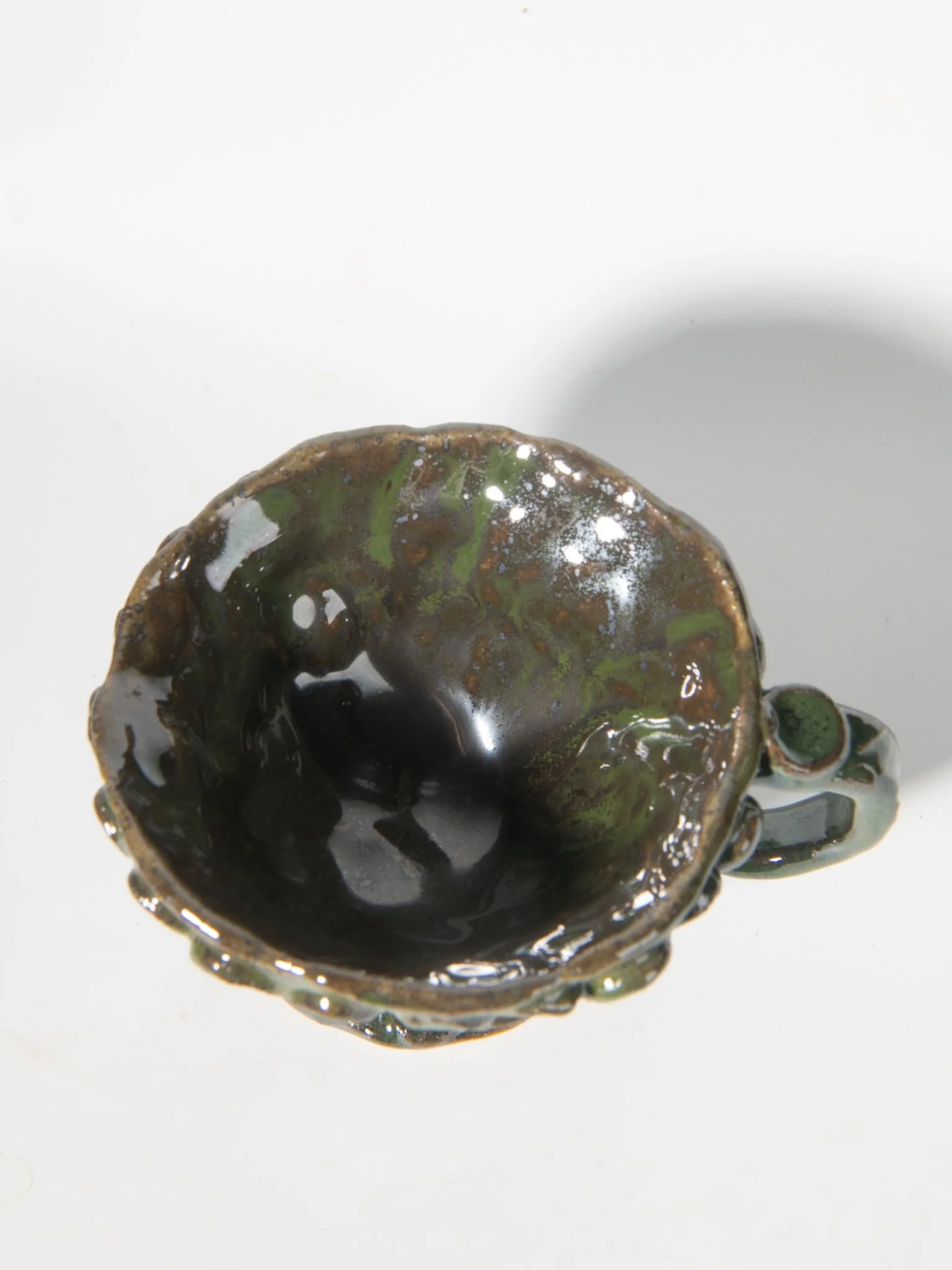 Inside of whimsical cup with black and green petals
