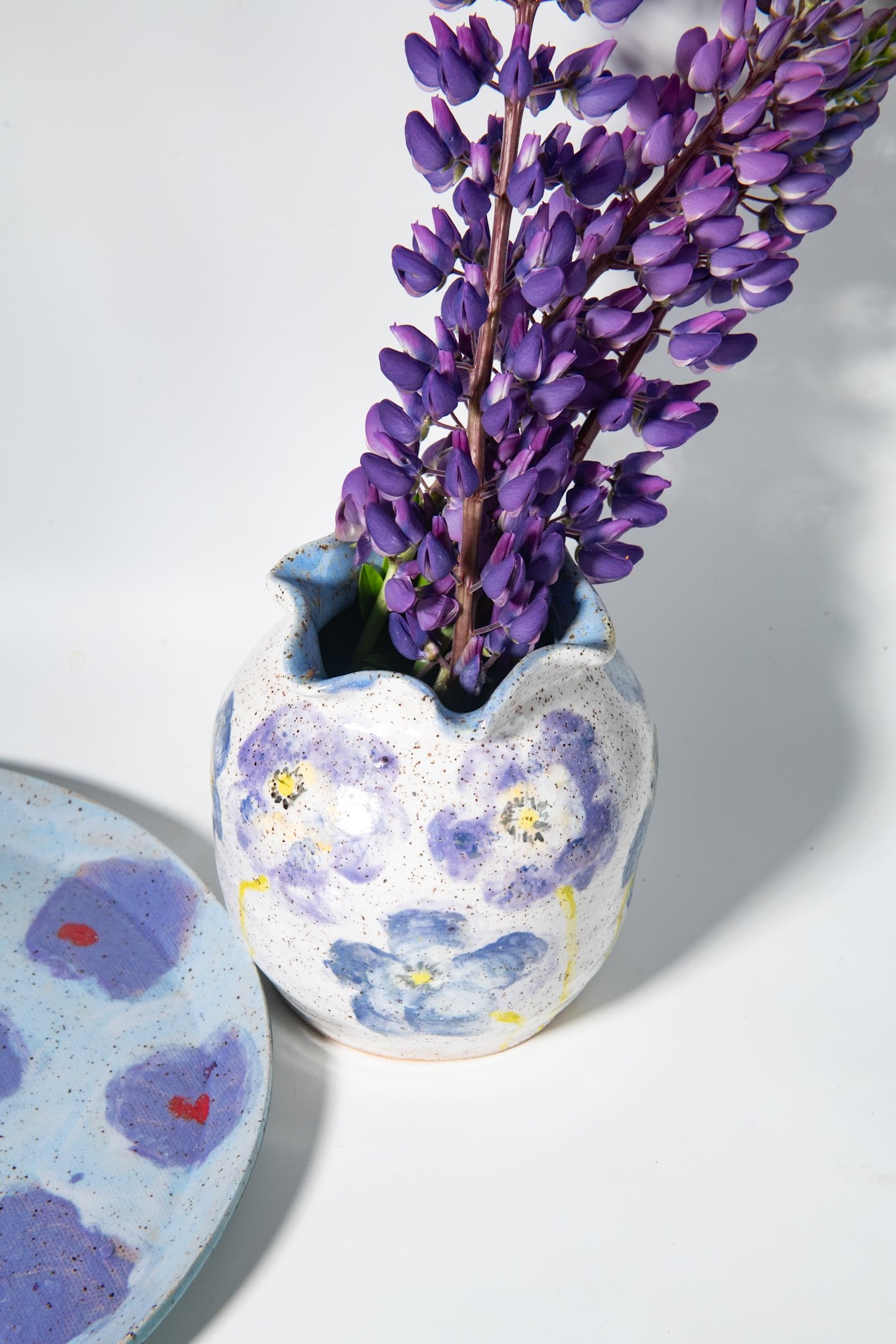 Purple poppy vase filled with purple lupines