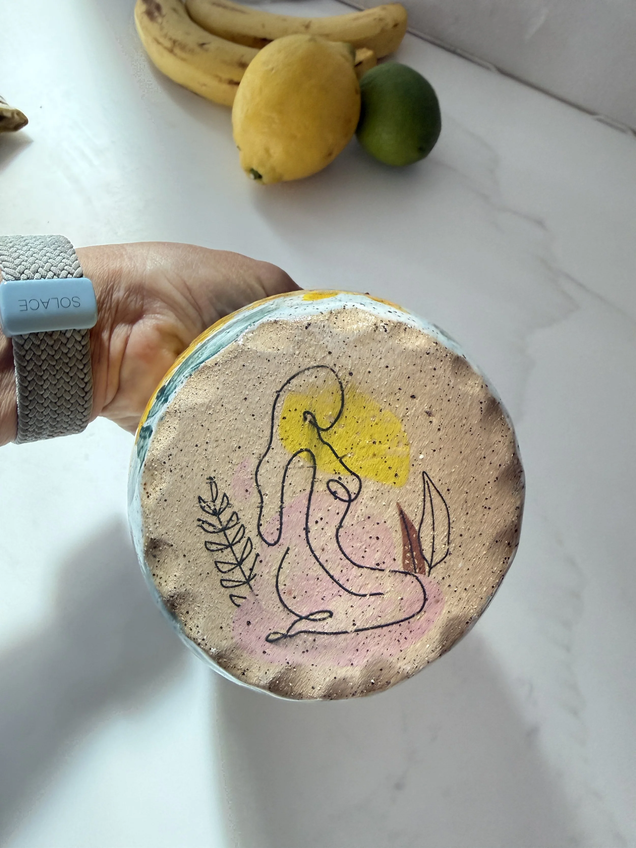 Bottom of sunflower vase with line drawing of woman