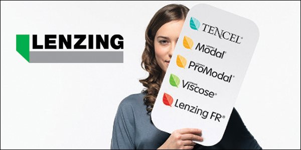A woman holding a sign with logos of Lenzing fiber brands including TENCEL, Modal, ProModal, Viscose, and Lenzing FR, in front of a Lenzing logo background.