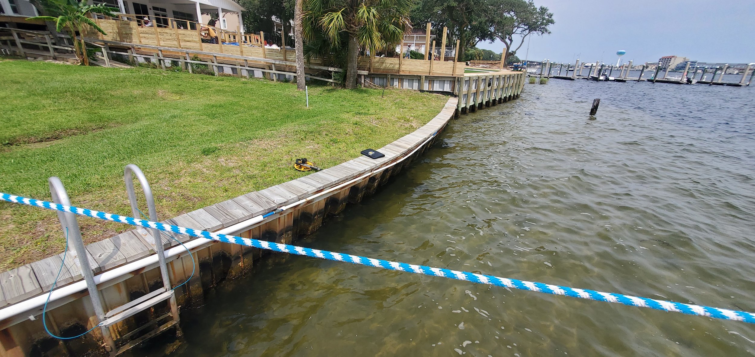 Failed seawall bowing toward water after corroded threaded rod anchors failed Florida Panhandle waterfront property