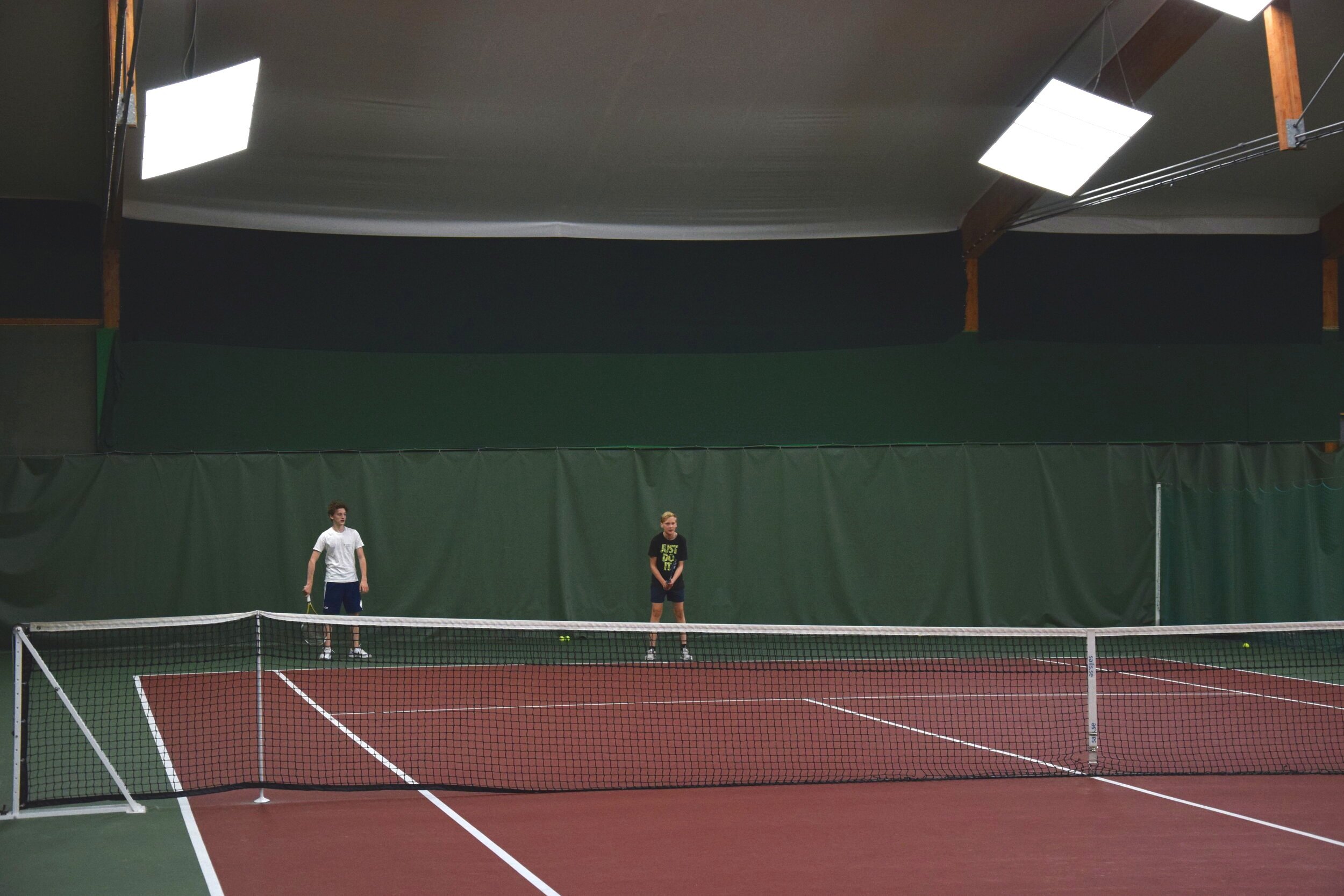 Två STS-eleversom spelar tennis i Stockholms Tennishall