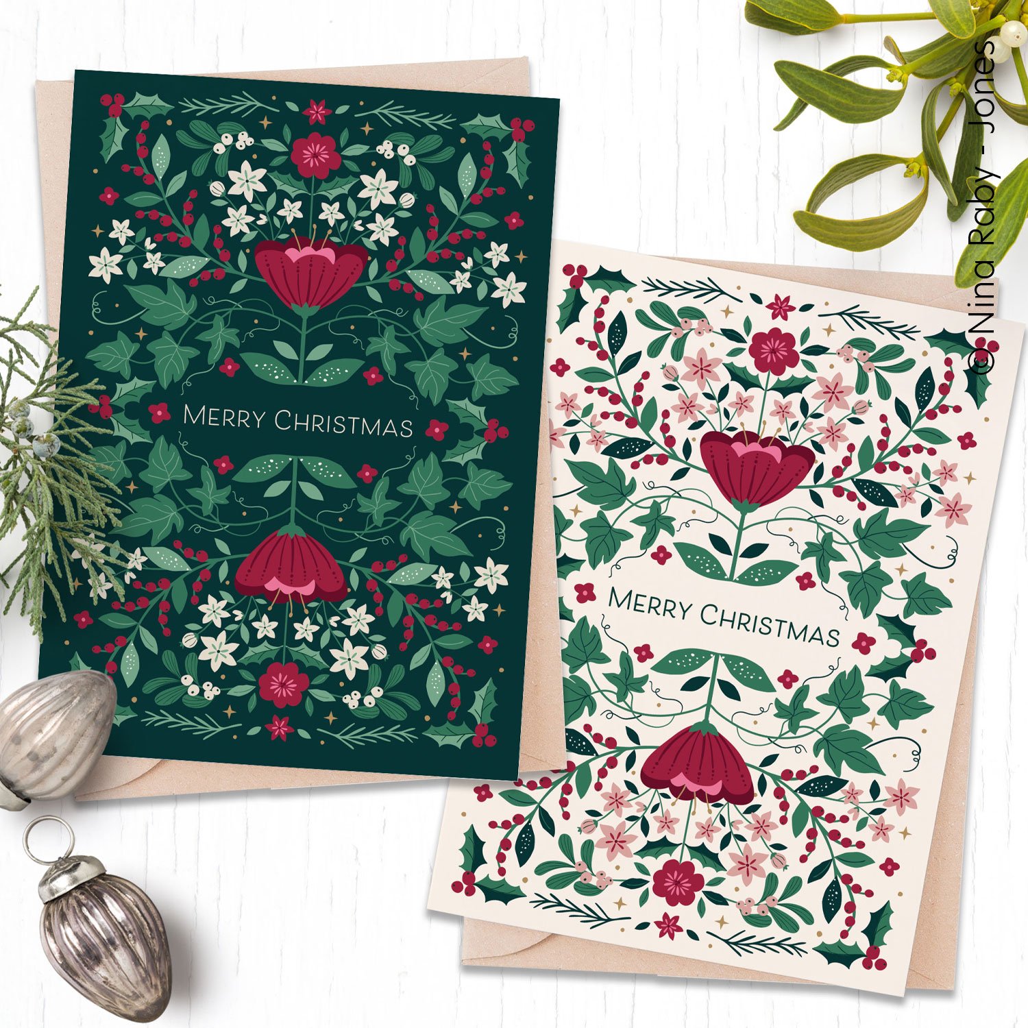 Two Christmas cards with floral and holly leaf designs, one dark green and one white, both saying "Merry Christmas" in the center, surrounded by holly, berries, and flowers. Pretty Scandinavian Christmas design. 