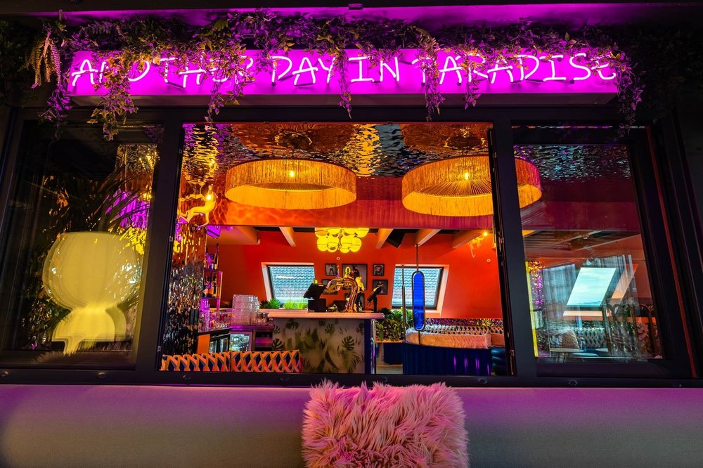 MAD APE sett fra takterrassen, med neonskilt og sittegrupper
