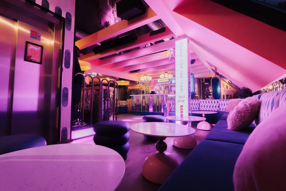 Sitteområde med rosa neon og metalliske flater i MAD APE