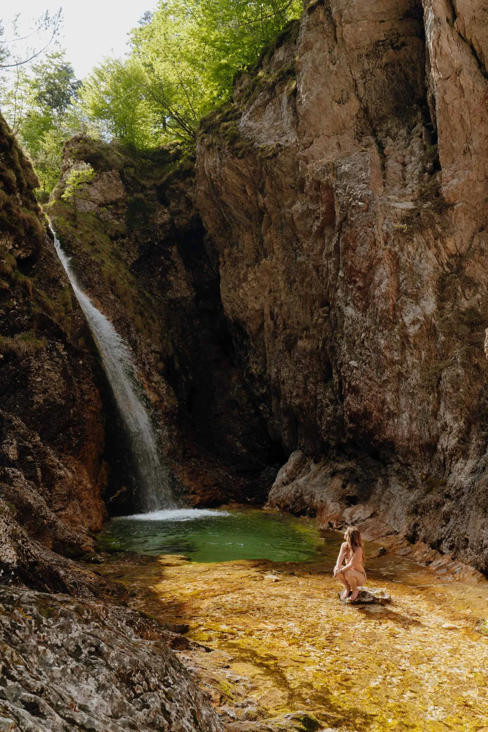 Woman swimming in a secret waterfall, Kekčeva Domačija, Alpe Adria Trail, Slovenia