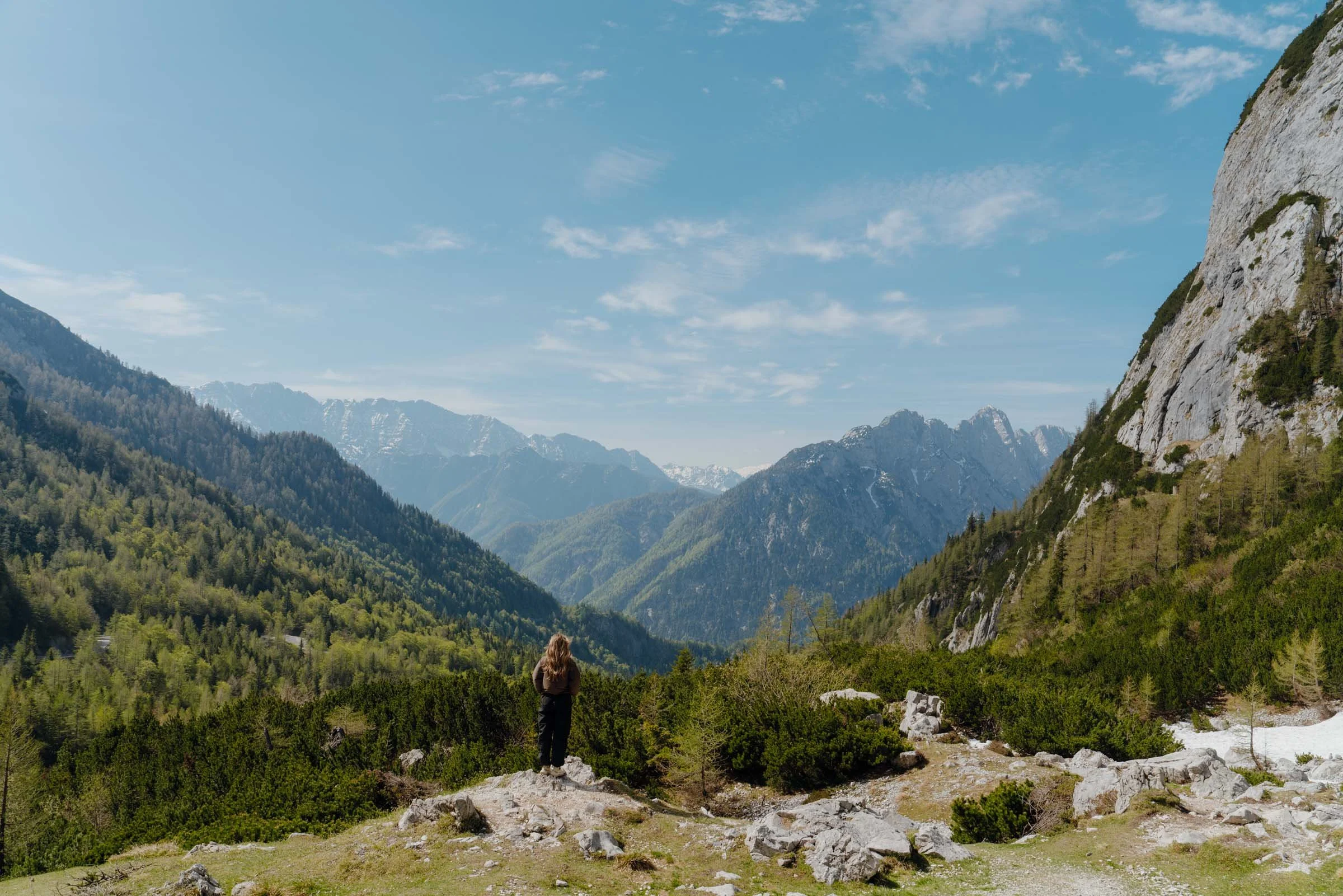 Woman standing in front of Vrsič Pass, Alpe Adria Trail, Slovenia